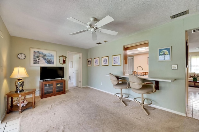 living area featuring carpet, visible vents, ceiling fan, and baseboards