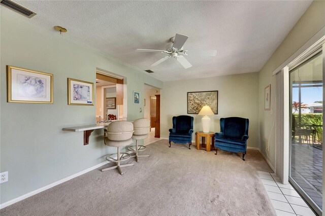 sitting room featuring a textured ceiling, visible vents, ceiling fan, and light colored carpet