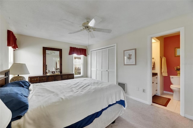 bedroom featuring light colored carpet, visible vents, baseboards, a closet, and a ceiling fan