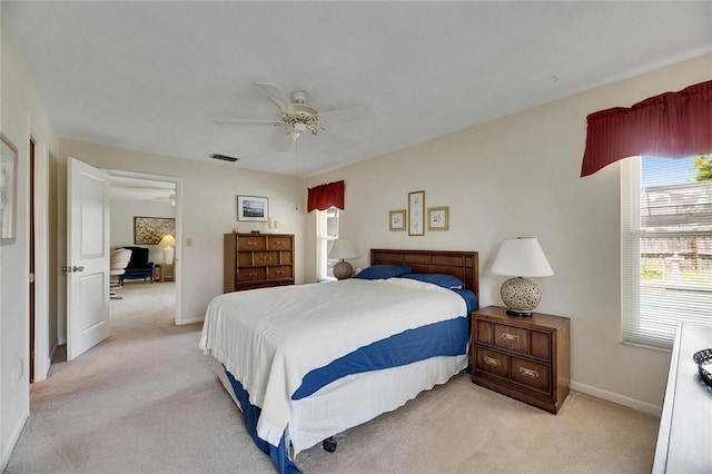 bedroom with baseboards, visible vents, ceiling fan, and light colored carpet
