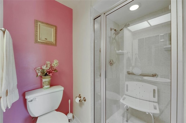 bathroom featuring toilet and a stall shower