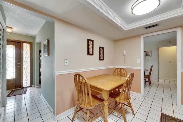 dining space with light tile patterned floors, visible vents, ornamental molding, and baseboards