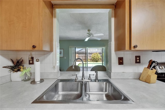 kitchen with a sink, tasteful backsplash, and light countertops