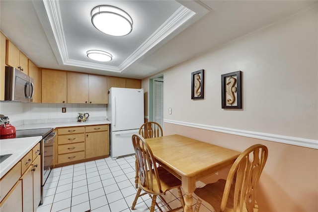 kitchen featuring appliances with stainless steel finishes, a raised ceiling, light brown cabinets, light countertops, and light tile patterned flooring