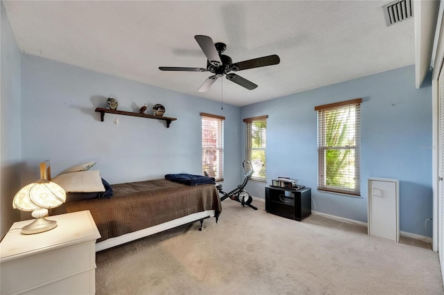 bedroom featuring baseboards, visible vents, a ceiling fan, and carpet