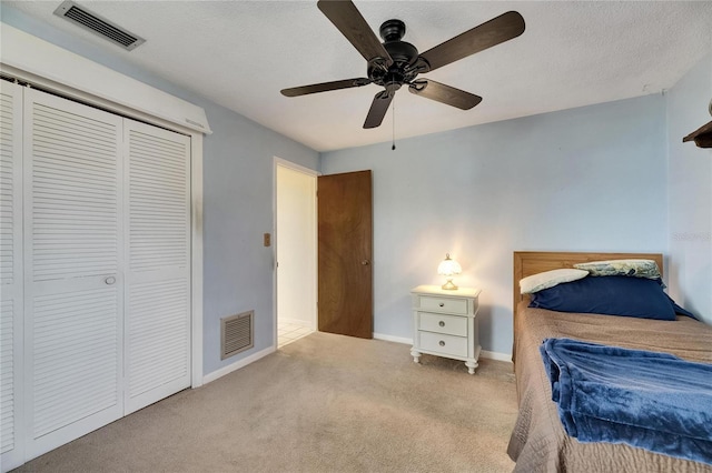 bedroom with visible vents, a ceiling fan, carpet flooring, and a closet