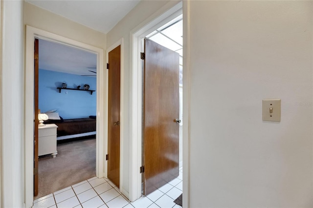 corridor with light tile patterned flooring and light carpet