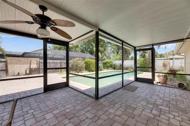 unfurnished sunroom with a ceiling fan