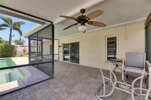 view of patio featuring fence, ceiling fan, a sunroom, and a fenced in pool