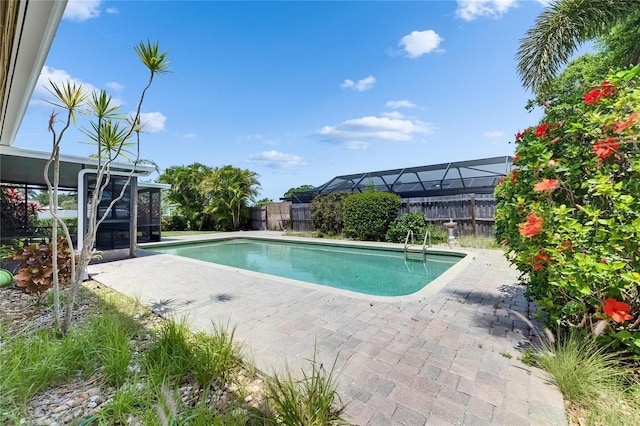 view of pool with a sunroom, a fenced in pool, a fenced backyard, and a patio area