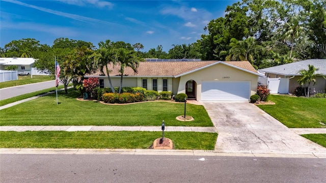 ranch-style home featuring a front lawn, driveway, a garage, and stucco siding