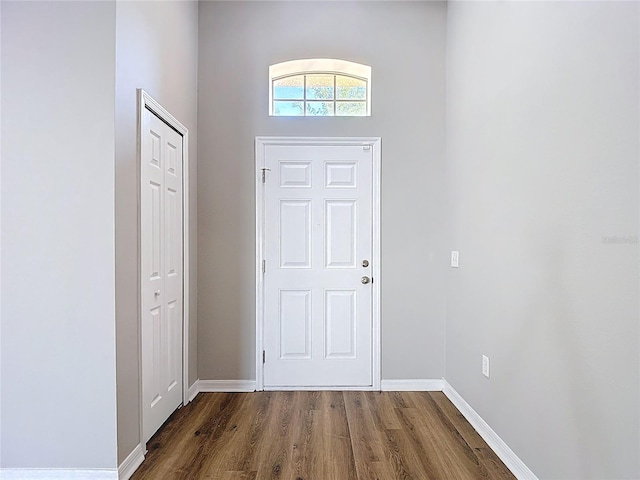 foyer featuring dark wood finished floors and baseboards