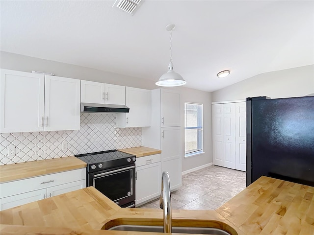 kitchen with freestanding refrigerator, under cabinet range hood, wooden counters, black electric range, and visible vents
