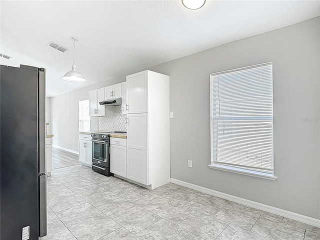 kitchen with range with electric cooktop, visible vents, white cabinetry, baseboards, and freestanding refrigerator
