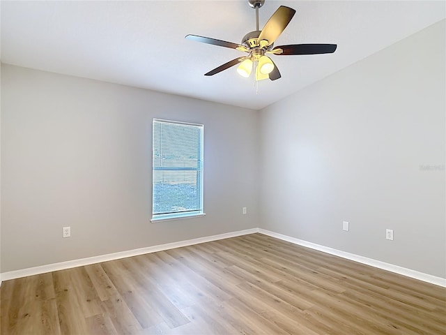 empty room with baseboards, ceiling fan, and light wood finished floors