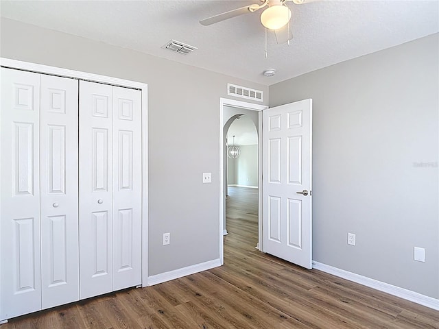 unfurnished bedroom featuring baseboards, visible vents, and wood finished floors