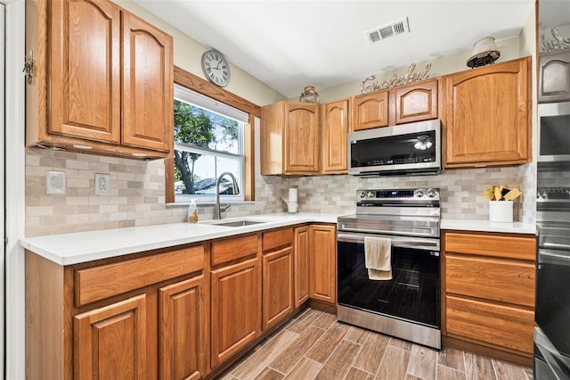 2134 6th Ave N, Saint Petersburg, FL 33713 - kitchen featuring visible vents, light countertops, a sink, light wood-style flooring, and stainless steel appliances