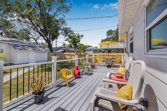 2134 6th Ave N, Saint Petersburg, FL 33713 - wooden deck featuring outdoor dining area, fence, and an outbuilding