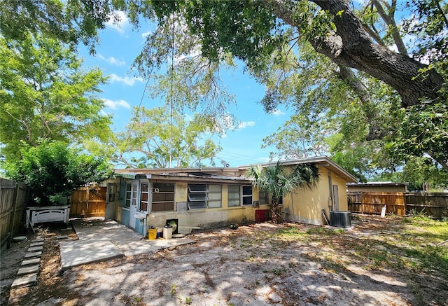 rear view of property featuring cooling unit, a fenced backyard, and a patio area