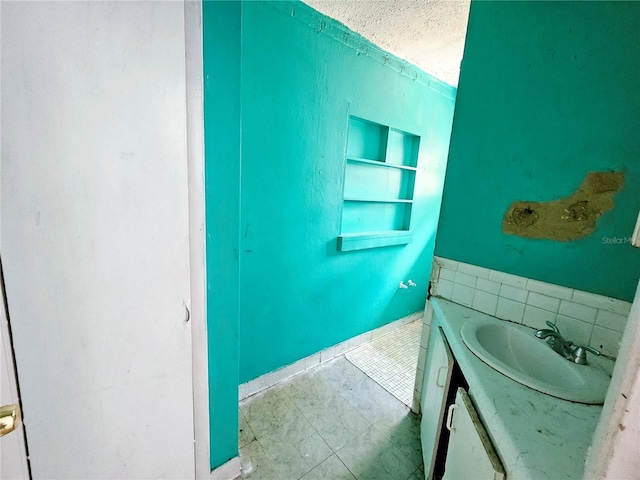bathroom with a textured ceiling and vanity