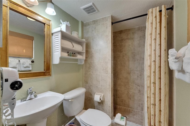 1420 Bayshore Blvd Unit 409, Dunedin, FL 34698 - bathroom with a shower stall, a sink, a textured ceiling, and toilet
