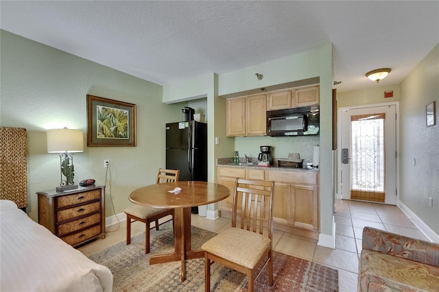 1420 Bayshore Blvd Unit 409, Dunedin, FL 34698 - kitchen featuring black appliances, light brown cabinets, light tile patterned floors, baseboards, and a sink