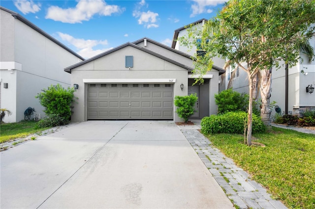 9617 Channing Hill Dr, Ruskin, FL 33573 - ranch-style home featuring a front lawn, driveway, a garage, and stucco siding