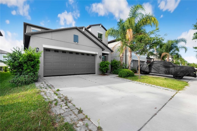 9617 Channing Hill Dr, Ruskin, FL 33573 - view of front of house with an attached garage, driveway, and stucco siding