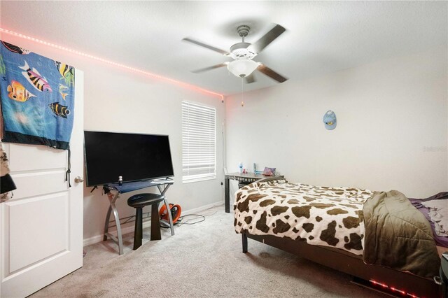 9617 Channing Hill Dr, Ruskin, FL 33573 - bedroom with baseboards, a ceiling fan, and light carpet
