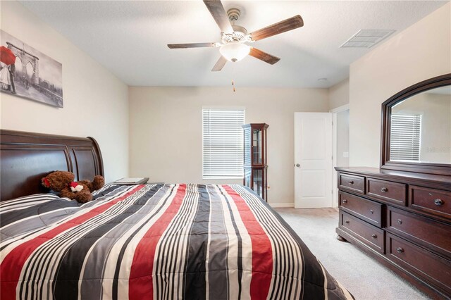 9617 Channing Hill Dr, Ruskin, FL 33573 - bedroom with light colored carpet, visible vents, ceiling fan, and baseboards