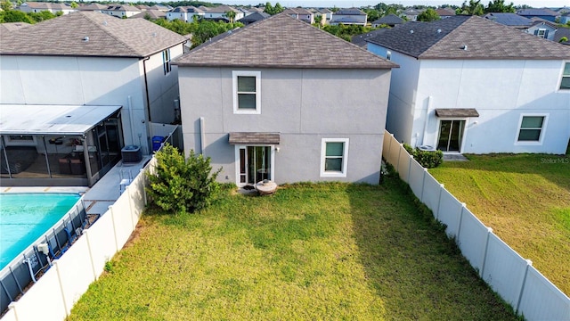 9617 Channing Hill Dr, Ruskin, FL 33573 - rear view of house with a sunroom, a residential view, a fenced backyard, roof with shingles, and stucco siding