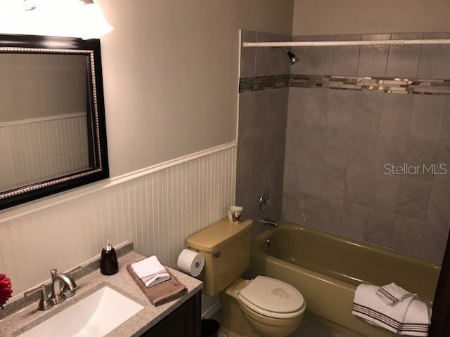 2450 Canadian Way Unit 6, Clearwater, FL 33763 - bathroom with toilet, tub / shower combination, vanity, and a wainscoted wall