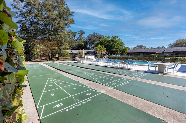view of home's community featuring a pool and fence