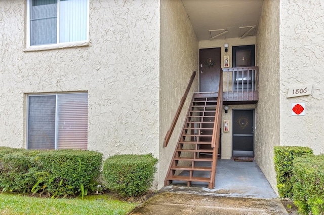 doorway to property featuring stucco siding
