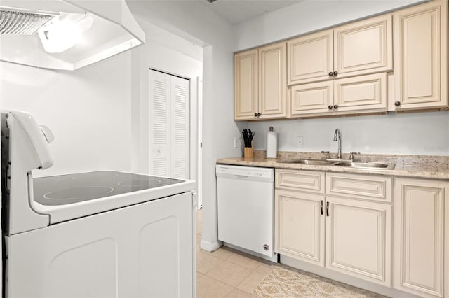 kitchen featuring white appliances, cream cabinets, light tile patterned floors, light countertops, and a sink