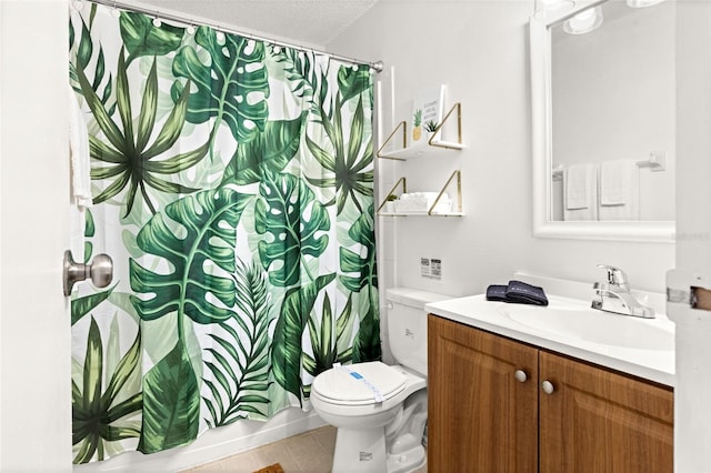 bathroom featuring tile patterned floors, toilet, a textured ceiling, and vanity