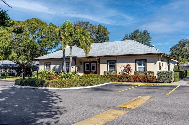 view of front facade with uncovered parking and stucco siding