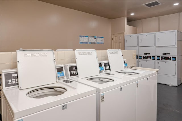 shared laundry area featuring stacked washer / drying machine, washing machine and clothes dryer, recessed lighting, and visible vents