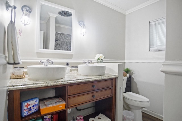 full bath featuring crown molding, toilet, double vanity, and a sink