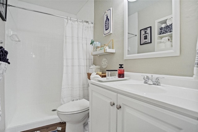 bathroom with toilet, a tile shower, wood finished floors, and vanity