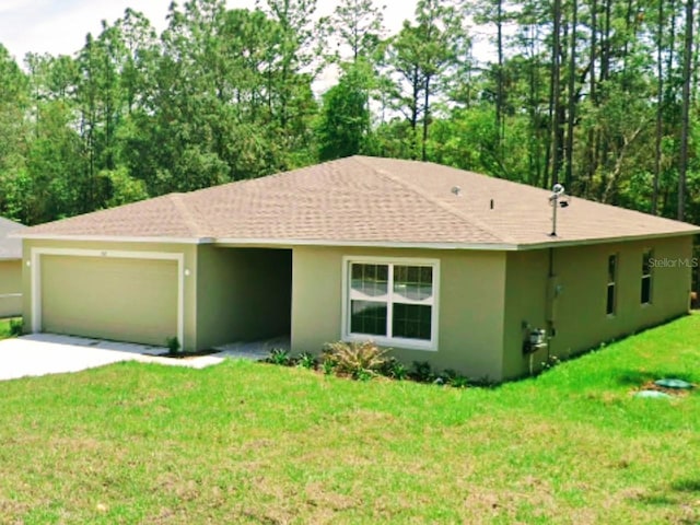 single story home featuring roof with shingles, a front yard, concrete driveway, an attached garage, and stucco siding