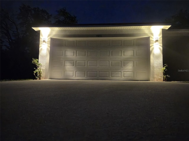view of garage at twilight