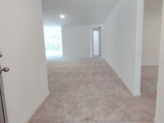 empty room with baseboards, recessed lighting, and light colored carpet