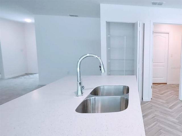 kitchen featuring visible vents, a sink, and light countertops