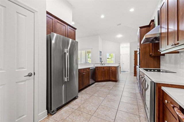 kitchen featuring a peninsula, recessed lighting, wall chimney exhaust hood, tasteful backsplash, and appliances with stainless steel finishes