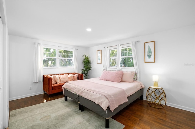 bedroom featuring baseboards, recessed lighting, wood finished floors, and multiple windows