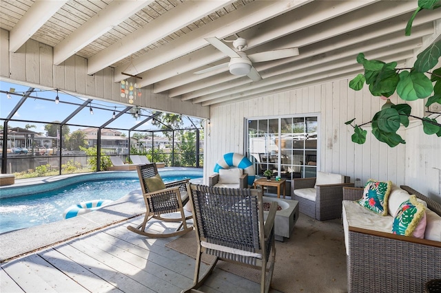 outdoor pool with ceiling fan, outdoor lounge area, and glass enclosure