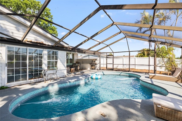 view of pool with a lanai, fence, a fenced in pool, and a patio area