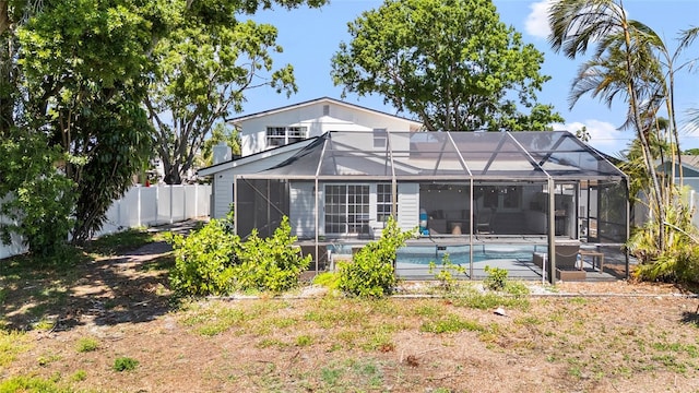 rear view of property with a patio, fence, glass enclosure, and an outdoor pool