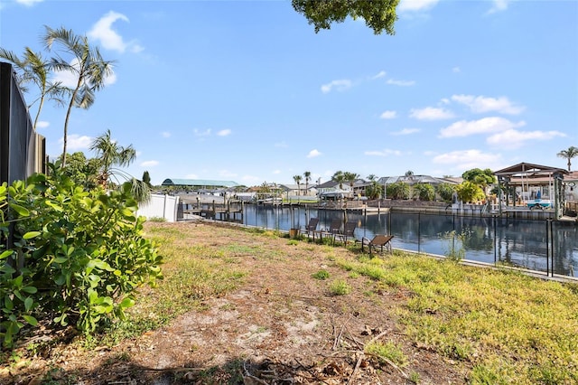 view of yard with a water view and a dock
